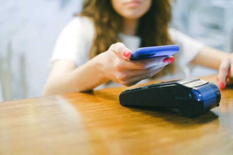 девушка использует NFC для оплаты со смартфона