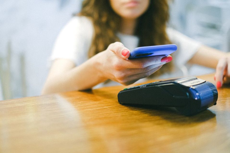 девушка использует NFC для оплаты со смартфона