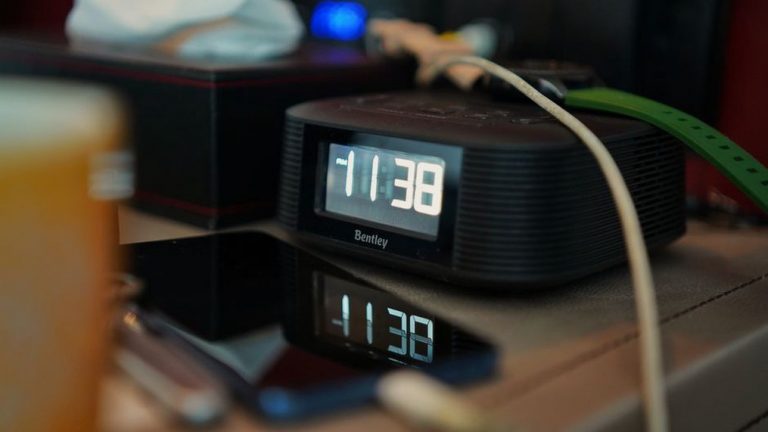 будильник на смартфоне рядом с кроватью